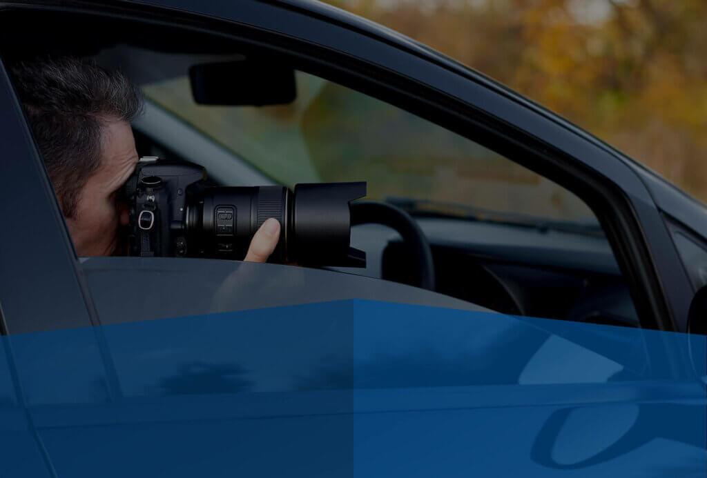 Private investigator conducting covert surveillance from a parked vehicle